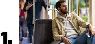 坐在公交车上佩戴 Bose QuietComfort 消噪耳塞 II 的男士