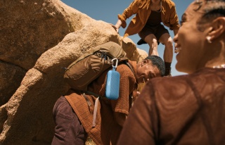 一群朋友在听着 Bose SoundLink Flex 便携式扬声器（第 2 代）播放的音乐攀岩。