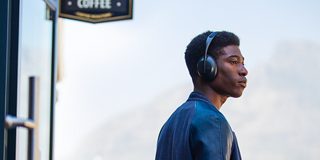 戴着黑色款 Bose 700 无线消噪耳机的男士