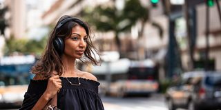戴着黑色款 Bose 700 无线消噪耳机的女士