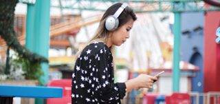 Woman wearing QuietComfort 35 wireless headphones II outside