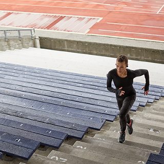一位佩戴 SoundSport Free 无线耳机的女士在登体育馆的台阶