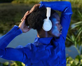 室外一位佩戴 Bose QuietComfort Ultra 无线消噪耳机的男士