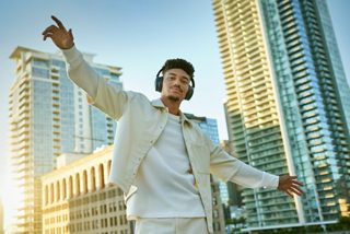 室外一位佩戴 Bose QuietComfort 消噪耳机的男士