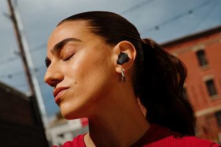 一位在户外佩戴 Bose QuietComfort 消噪耳塞 Ultra II 的女士。