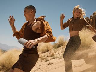 朋友们在沙丘上一边跑步，一边聆听 Bose SoundLink Flex 便携式扬声器（第 2 代）播放的音乐。