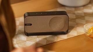 桌子上放置的暖木色 Bose SoundLink Home 蓝牙扬声器。