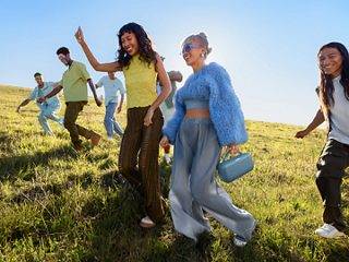 年轻人走过田野，聆听 Bose SoundLink Max 手提音箱带来的美妙音乐