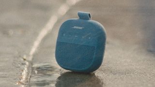 Bose SoundLink Micro 便携式扬声器 II 置于阳光下的地面上。