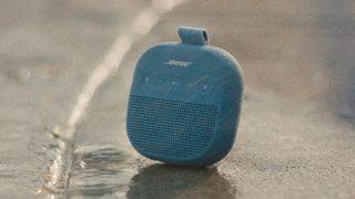 Bose SoundLink Micro 便携式扬声器 II 置于阳光下的地面上。