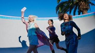 三位女士外出散步，其中一位女士手拿一个冷丁香紫 SoundLink Flex 蓝牙扬声器