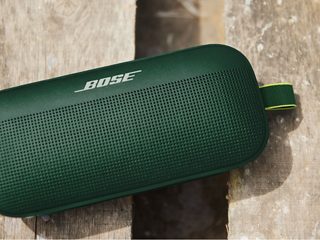掉落在地、沾染泥水的丝柏绿 SoundLink Flex 蓝牙扬声器